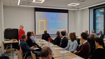 Zdjęcie uczestników spotkania siedzących przy stole.